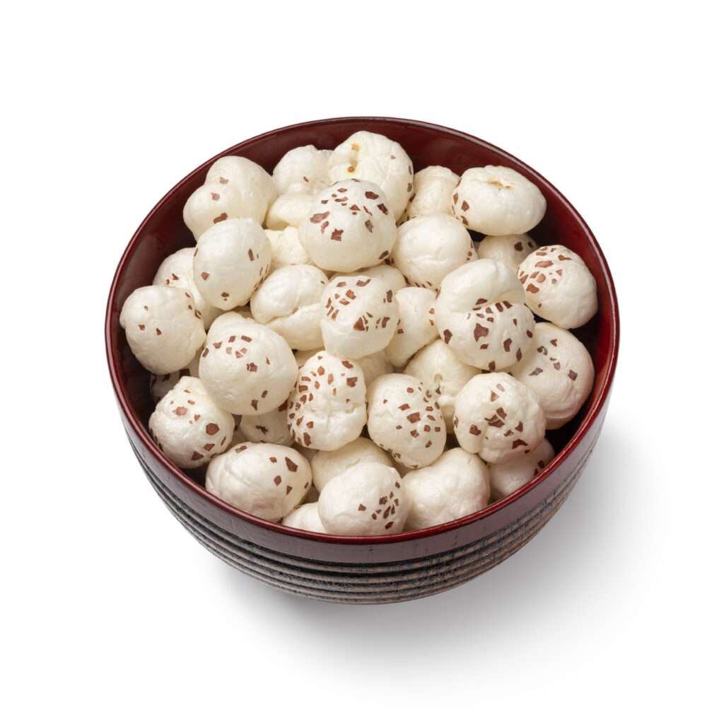 Bowl with puffed Lotus seed isolated on white background close up